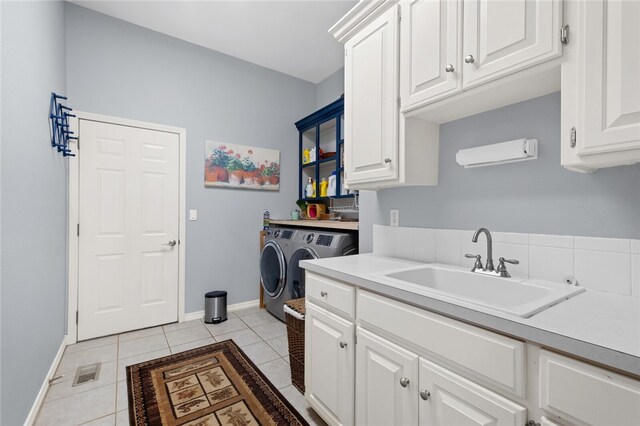 laundry area with cabinets, sink, light tile patterned floors, and washing machine and dryer