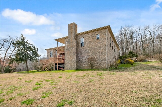 rear view of property featuring a deck and a yard