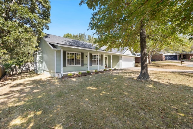 single story home featuring covered porch, a garage, and a front lawn