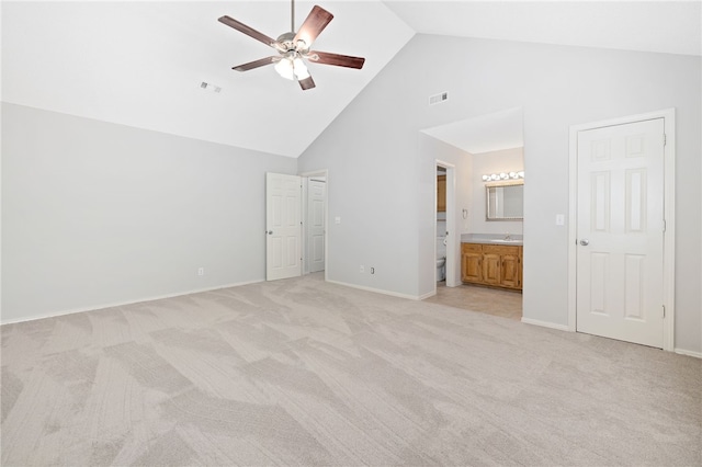 unfurnished bedroom featuring light carpet, connected bathroom, high vaulted ceiling, and ceiling fan