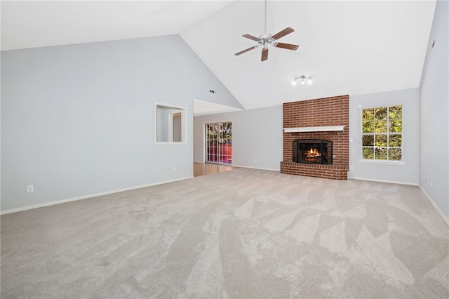 unfurnished living room featuring ceiling fan, high vaulted ceiling, light colored carpet, and a brick fireplace