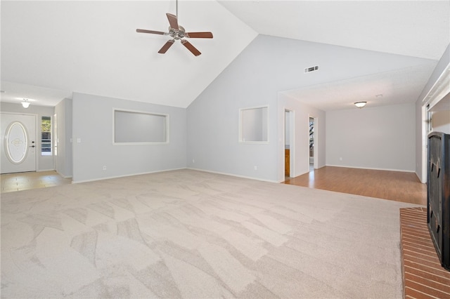 unfurnished living room featuring ceiling fan, light colored carpet, and high vaulted ceiling