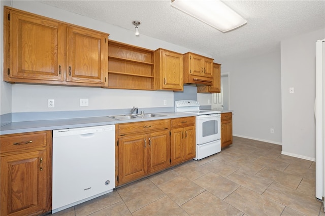 kitchen featuring a textured ceiling, white appliances, and sink