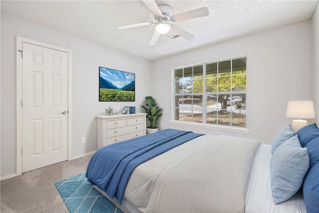 bedroom featuring carpet, ceiling fan, and a textured ceiling