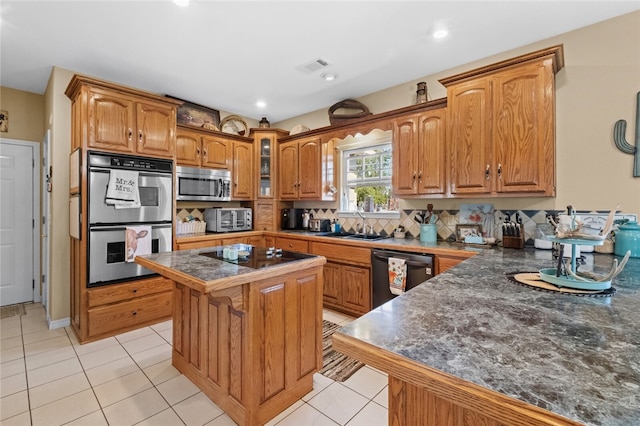 kitchen with light tile patterned flooring, sink, a kitchen island, stainless steel appliances, and a kitchen bar