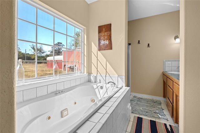 bathroom featuring a wealth of natural light, tile patterned floors, and a relaxing tiled tub