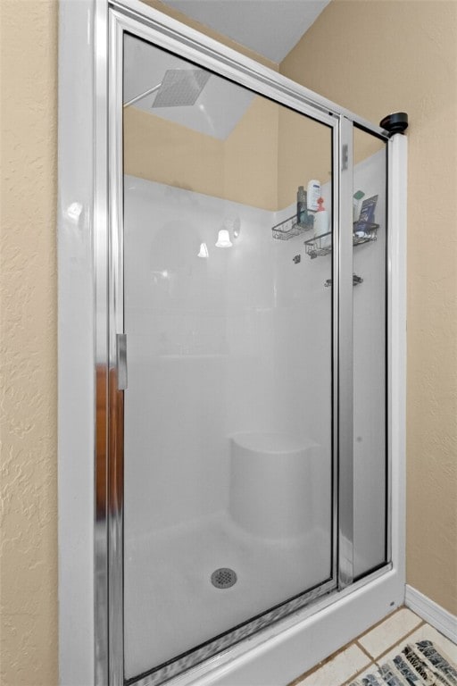 bathroom with tile patterned floors and an enclosed shower