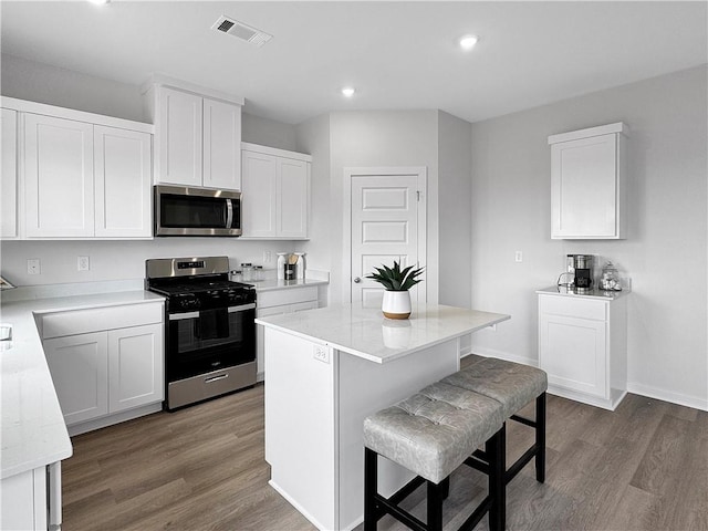 5395 Selah St, Springdale, AR 72764 - kitchen featuring stainless steel appliances, dark wood finished floors, a breakfast bar, white cabinets, and recessed lighting