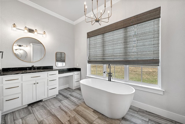 bathroom with ornamental molding, a chandelier, vanity, and a bathtub