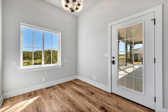 entryway with an inviting chandelier and light hardwood / wood-style floors