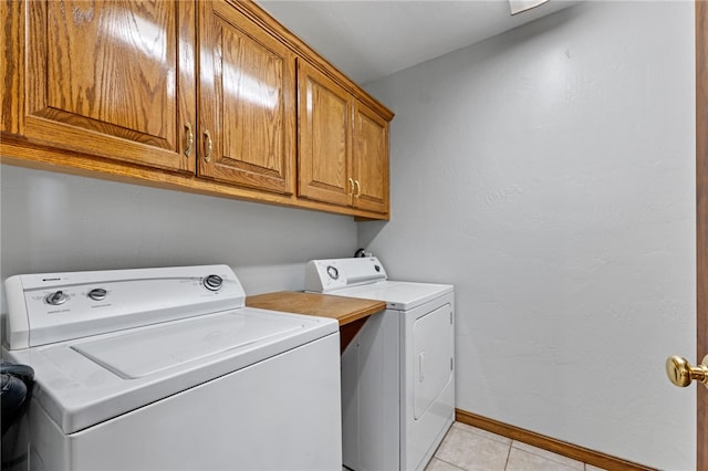 laundry room featuring cabinets, independent washer and dryer, and light tile patterned flooring