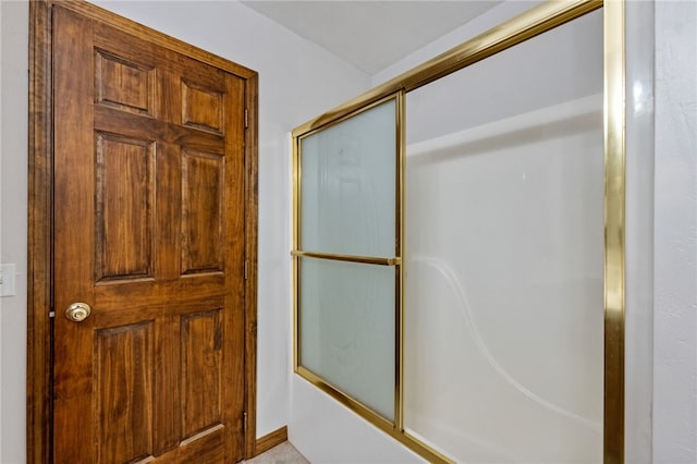 bathroom with shower / bath combination with glass door