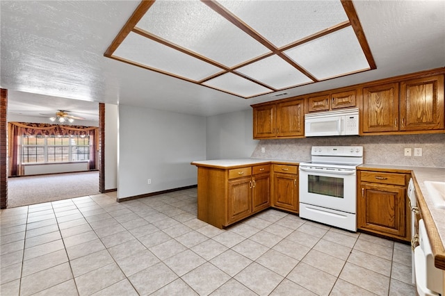 kitchen with ceiling fan, kitchen peninsula, a textured ceiling, white appliances, and light tile patterned floors