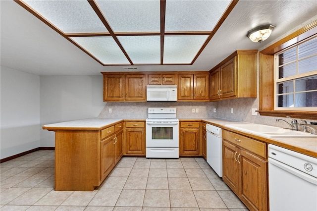 kitchen with kitchen peninsula, backsplash, white appliances, sink, and light tile patterned floors