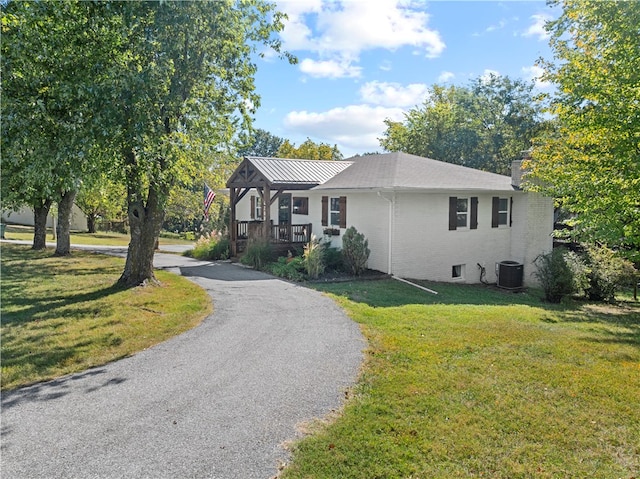 view of front of home featuring a front yard and central AC unit