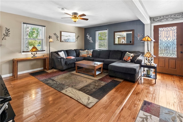 living room with hardwood / wood-style floors, beam ceiling, and ceiling fan