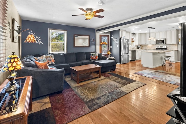 living room featuring light hardwood / wood-style flooring and ceiling fan