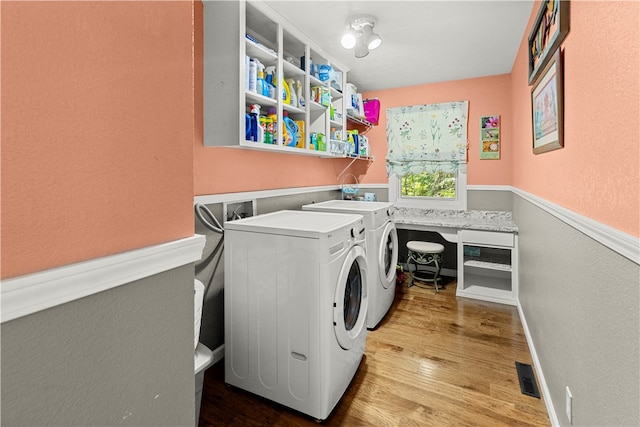 laundry room with light wood-type flooring and washing machine and clothes dryer