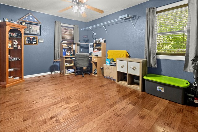 home office with ceiling fan and hardwood / wood-style flooring