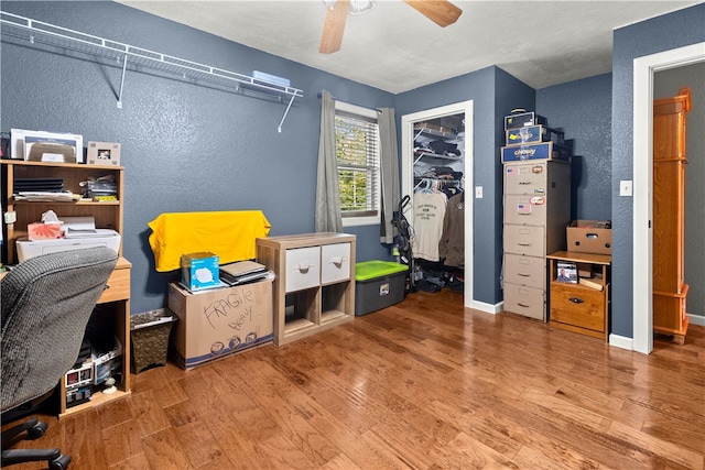 bedroom with a closet, wood-type flooring, and ceiling fan