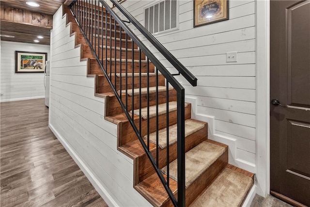 stairs with wood walls and wood-type flooring