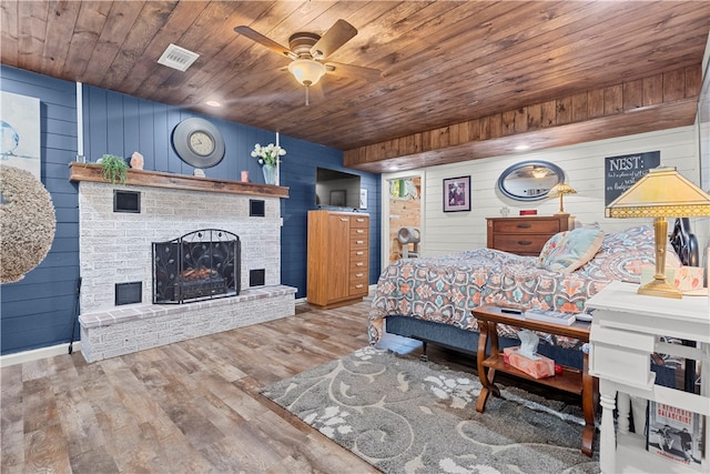 bedroom with hardwood / wood-style flooring, wooden ceiling, and wood walls