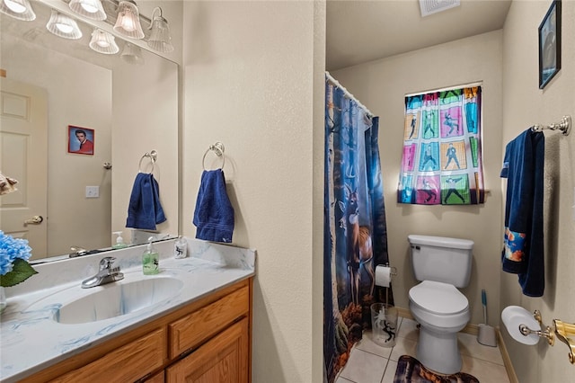 bathroom with tile patterned floors, vanity, toilet, and walk in shower