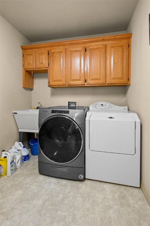 laundry room featuring washer and dryer and cabinets