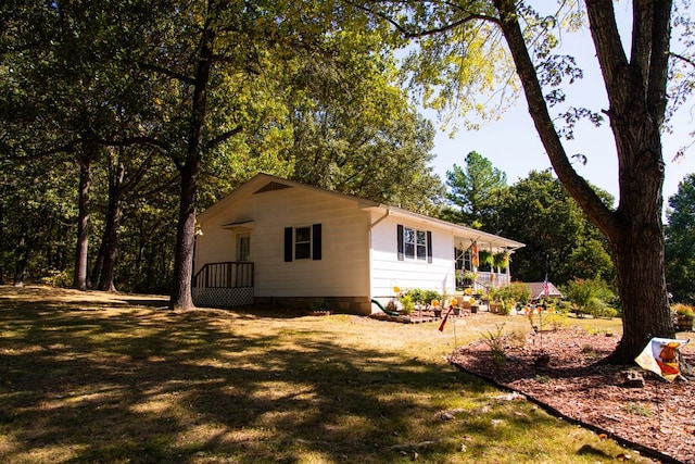 view of side of home with a yard