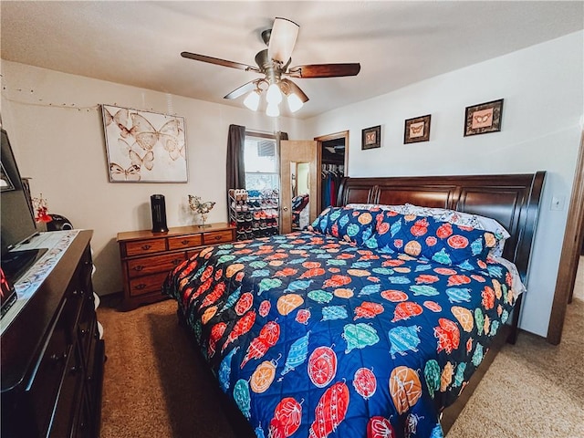 carpeted bedroom featuring ceiling fan, a spacious closet, and a closet