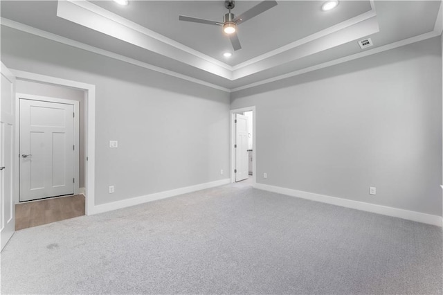 spare room featuring ornamental molding, ceiling fan, a raised ceiling, and carpet flooring