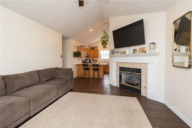 living room featuring dark hardwood / wood-style flooring, a fireplace, and vaulted ceiling