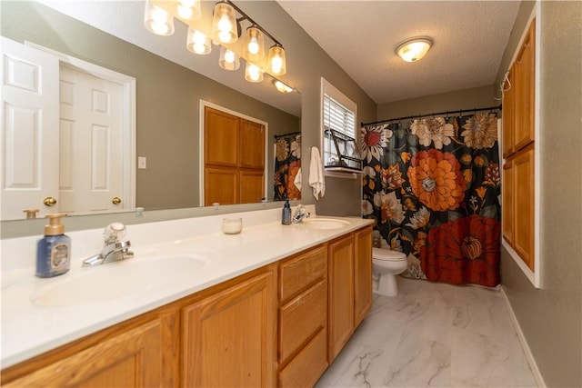 bathroom with vanity, toilet, and a textured ceiling