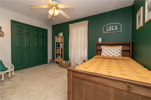 carpeted bedroom featuring ceiling fan, a closet, and a textured ceiling