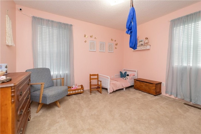 bedroom featuring carpet flooring and a textured ceiling