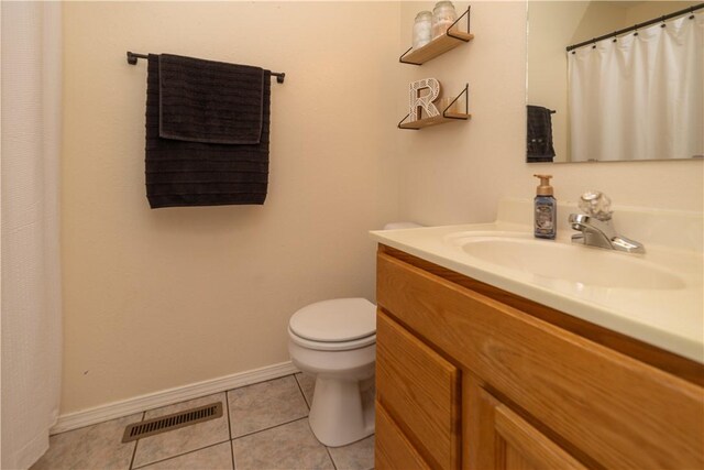 bathroom featuring tile patterned flooring, vanity, and toilet