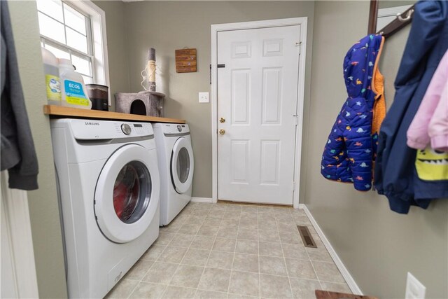 laundry area featuring separate washer and dryer and light tile patterned floors