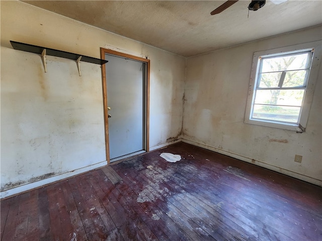 unfurnished bedroom with ceiling fan and dark hardwood / wood-style floors