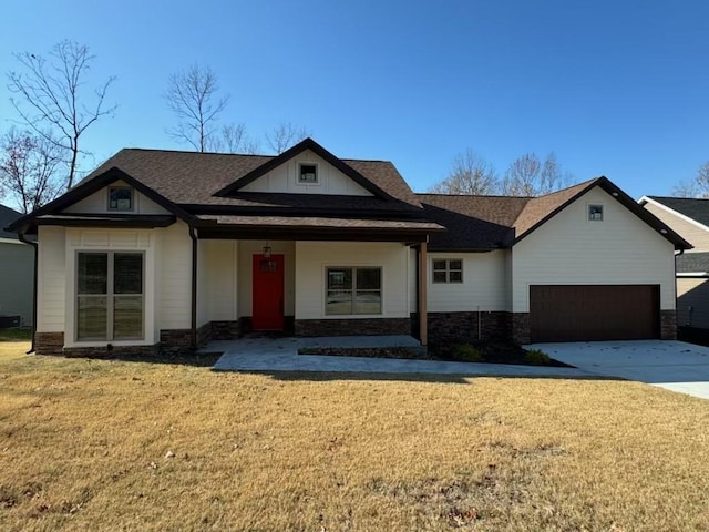 single story home with a porch, a garage, and a front lawn