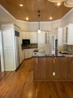 kitchen featuring decorative light fixtures, hardwood / wood-style floors, and white cabinetry