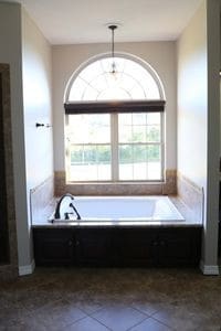 bathroom with tile patterned flooring and a washtub