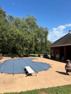 view of pool with a diving board and a patio area