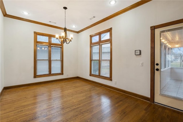 unfurnished dining area featuring a notable chandelier, wood-type flooring, ornamental molding, and a healthy amount of sunlight