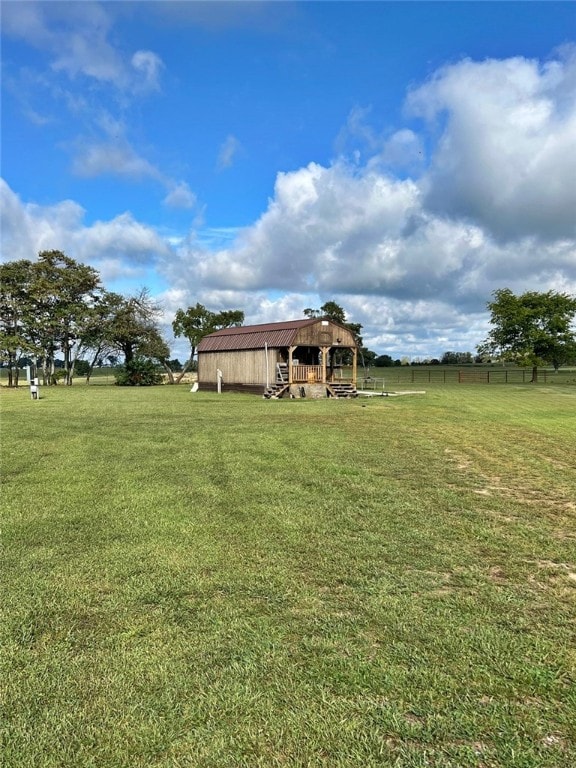 view of yard featuring a rural view and an outbuilding