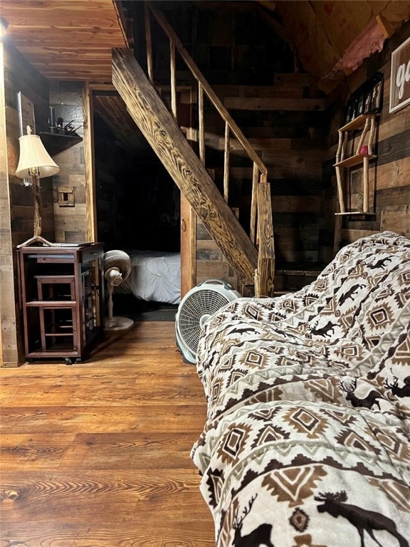 bedroom with wood walls and wood-type flooring