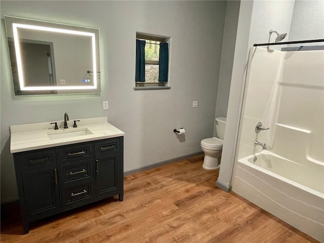 full bathroom with hardwood / wood-style floors, toilet, vanity, and shower / tub combination