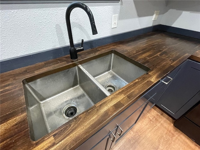 interior details featuring wooden counters, sink, and hardwood / wood-style floors