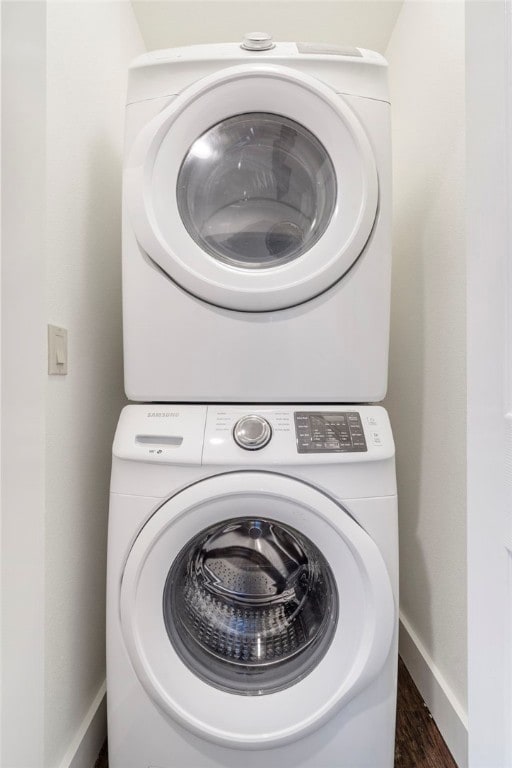 clothes washing area with stacked washer / dryer