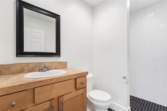 bathroom with vanity, toilet, tile patterned floors, and a tile shower