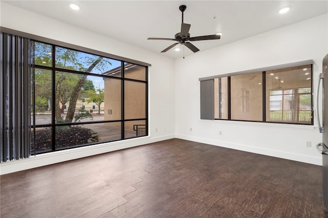 spare room featuring dark hardwood / wood-style floors, a healthy amount of sunlight, and ceiling fan